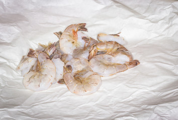 Raw Jumbo Shrimp on Wax Paper:  Raw, deveined  jumbo shrimp on a sheet of wax paper being prepped for sauteing.