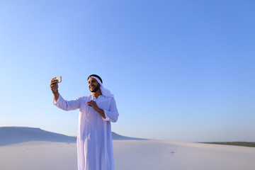 Portrait of Arabian sheikh man with gadget that communicates in 