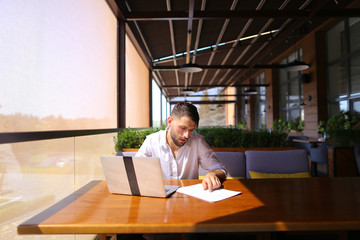 Inventory strategist working with laptop at cafe table.