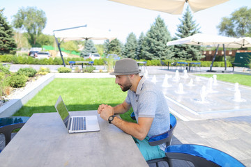 Close up hands typing on laptop keypad outside.