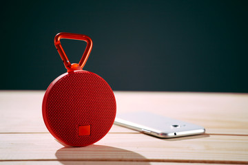 Red wireless speaker on wooden background