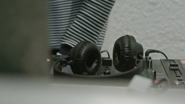 Male DJ play the music on the mixing console in the nightclub, closeup slow motion shot.