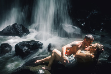 Erotic couple kissing near waterfall. Traveling at Bali.
