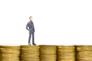 Figure miniature businessman or small people standing on the top stack of coin on white background for money and financial business concept.