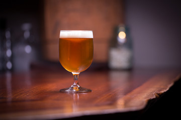 Goblet of India pale ale on a wood counter at a bar