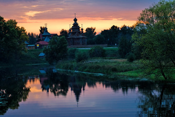 Fototapeta na wymiar Wooden Orthodox church with reflection in river. The monument of wooden architecture of Russia.Suzdal. Golden Ring of Russia