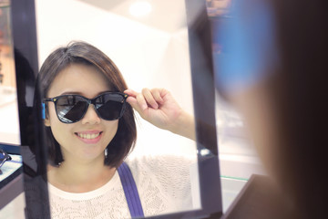 Young woman in sunglasses looking at camera in shop.