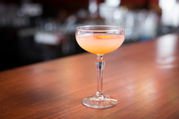 Side view of grapefruit and orange cocktail on bar