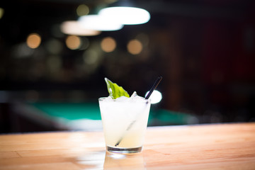 Close up on white mojito cocktail with bar background