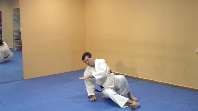 Aikido technique demonstration to students. Man doing aikido.