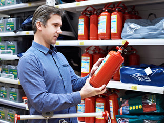 Man chooses and buys fire extinguisher in store