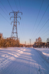 High-voltage pole in the winter at sunset