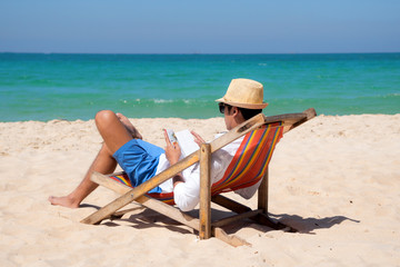 man enjoy and relax in comfortable reading book on the deck beach chair at summer holiday and long weekend vacation