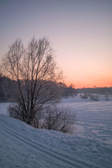 Fototapeta na wymiar Winter sunset on the frozen lake in park