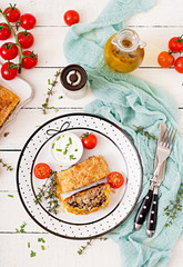 Appetizing strudel with minced beef, onions and herbs. Flat lay. Top view