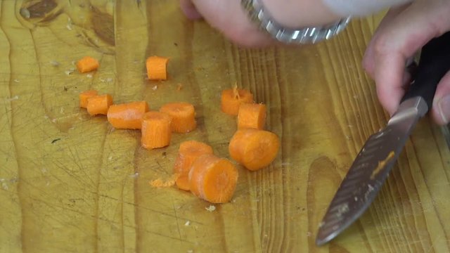 Chopping carrots on a cutting board over a sink