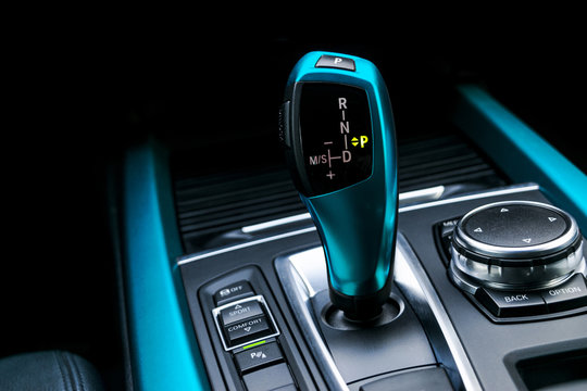 Blue Automatic gear stick (transmission) of a modern car, multimedia and navigation control buttons. Car interior details. Transmission shift.