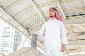 arab businessman looking on copy space while standing, young professional employee waiting for international partners outdoors near big company.portrait