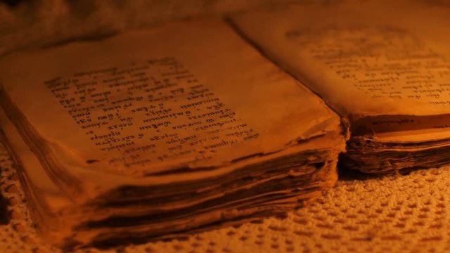 Elderly woman reading old book by candlelight

