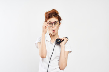 Young beautiful woman in glasses on white isolated background holds phone, emotions