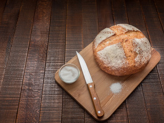 Bread and salt on a wooden table. Prepared according to the classic recipe in the oven.
