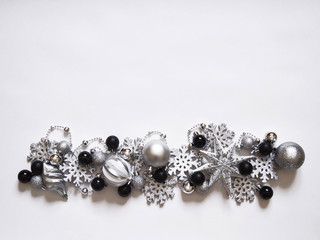Christmas decoration with balls and snowflakes. View from above. Colors are black, gray, silver and white. New Year.