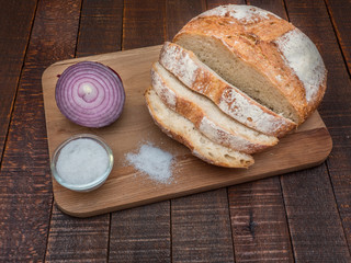 Bread and salt on a wooden table. Prepared according to the classic recipe in the oven.