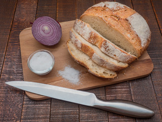 Bread and salt on a wooden table. Prepared according to the classic recipe in the oven.