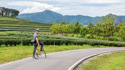 Naklejka premium Men riding a bicycle at Singha park Chiang Rai, Thailand.