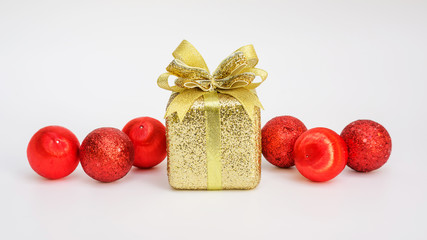 Gold gift box and red Christmas ball on a white background.