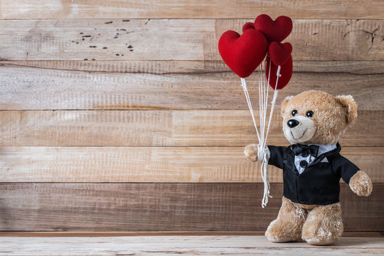 Teddy bear holding heart-shaped balloon