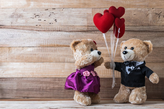 Teddy bear give heart-shaped balloon to his girl friend