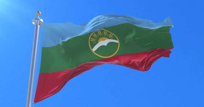 Flag of Karachay Cherkessia waving at wind with blue sky in slow, loop