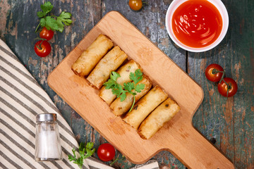 Vietnamese food. Delicious homemade spring rolls on wooden table.