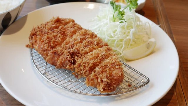 Tonkatsu a Japanese dish which consists of a breaded, deep-fried pork cutlet served with shredded cabbage miso soup and bowl of rice.