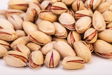 Close Up Group Of Dry, Fresh And Large Raw Pistachio Nuts In Shell Isolated On White Background, Selective Focus