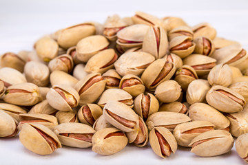 Close Up Group Of Dry, Fresh And Large Raw Pistachio Nuts In Shell Isolated On White Background, Selective Focus
