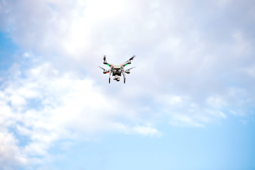 Quadcopter drone with the camera against the blue sky