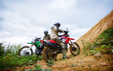 Fototapeta na wymiar Motocross racers on landscape