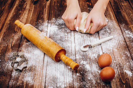 Woman makes Christmas pastry on the dough on wooden table