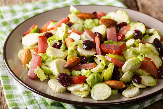 Healthy salad from Brussels sprouts, cranberries, almonds and ham close-up. horizontal
