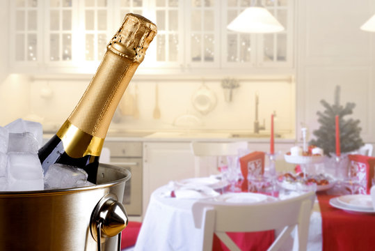 Sparkling Wine Bottle In Ice Bucket On Festive Kitchen Background