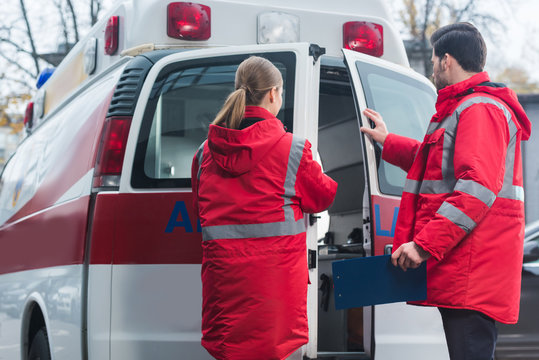 male and female paramedics closing ambulance doors