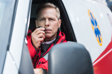 handsome middle aged paramedic talking by portable radio © LIGHTFIELD STUDIOS