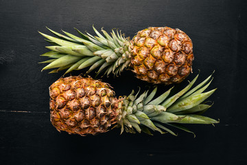 Pineapple on a wooden background. Top view. Free space for text.