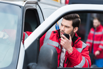 young handsome male paramedic standing near ambulance and talking by portable radio © LIGHTFIELD STUDIOS