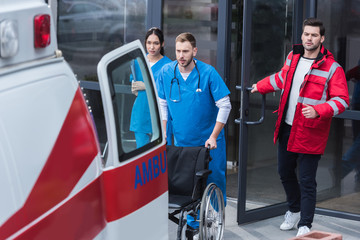 paramedics moving wheelchair from hospital to ambulance © LIGHTFIELD STUDIOS