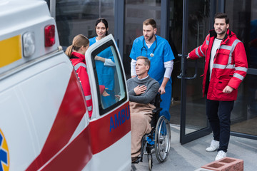 doctors helping man on wheelchair get to ambulance © LIGHTFIELD STUDIOS