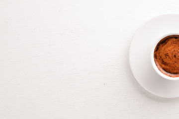 Espresso coffee cup on a white wooden background. Top view. Free space for text.