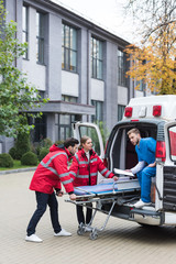 paramedics moving ambulance stretcher into car © LIGHTFIELD STUDIOS